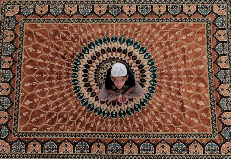 A boy looks up while waiting to break his fast, at the end of the first day of the holy month of Ramadan, on a rooftop of his home during the curfew amid concerns about the spread of the coronavirus disease (COVID-19), in Colombo, Sri Lanka April 25, 2020. REUTERS/Dinuka Liyanawatte     TPX IMAGES OF THE DAY