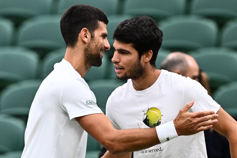 Novak Djokovic, left, shakes hands with Carlos Alcaraz during a practise session prior to their men's singles semi-finals matches at Wimbledon. AFP