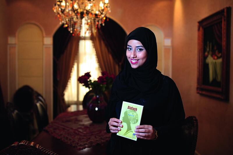 The author Alia Al Hazami, with her book Alatash, which she completed while at high school. Sarah Dea / The National