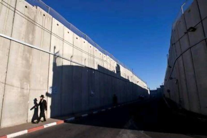 An ultra-Orthodox Jewish man walks past a section of the controversial Israeli barrier in Bethlehem. Israeli Jews were riled by last week’s suggestion from poll results that they have built an ‘apartheid state’ on Palestinian territory.