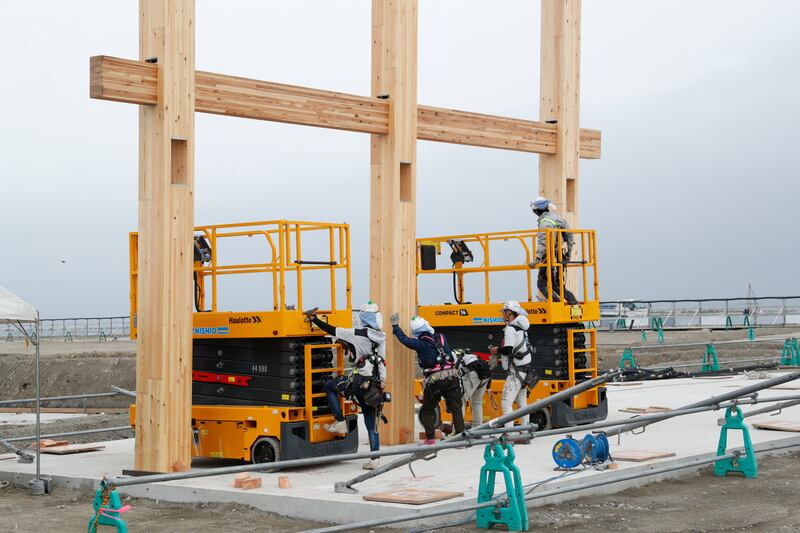 The wooden frames beng lowered into slots demarcated in the foundation. Photo: Japan Association for the 2025 World Exposition/ Obayashi Corporation 