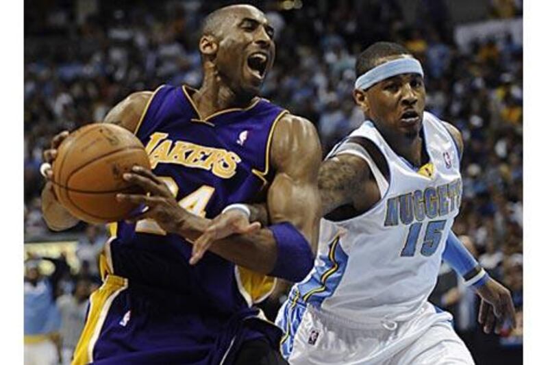 The Denver Nuggets forward Carmelo Anthony, right, reaches in on Los Angeles Lakers guard Kobe Bryant.