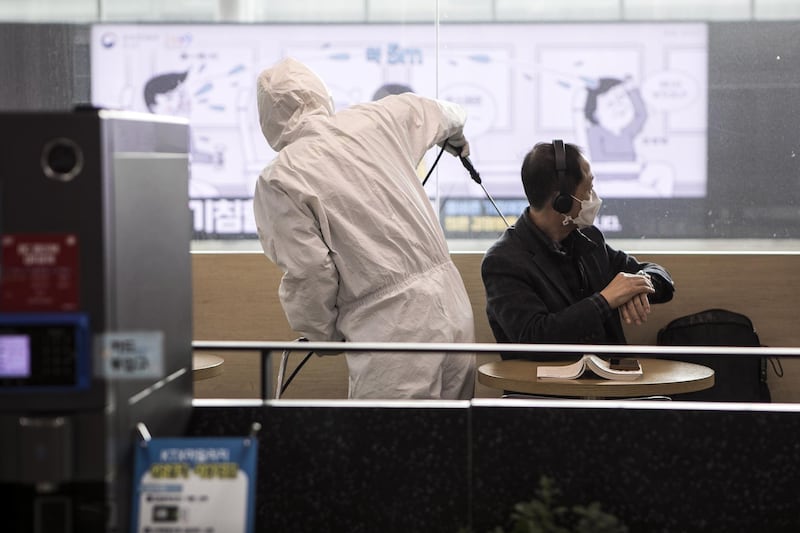 A disinfection worker, in protective gear, disinfects a waiting room in Seoul Station against the coronavirus. Getty Images