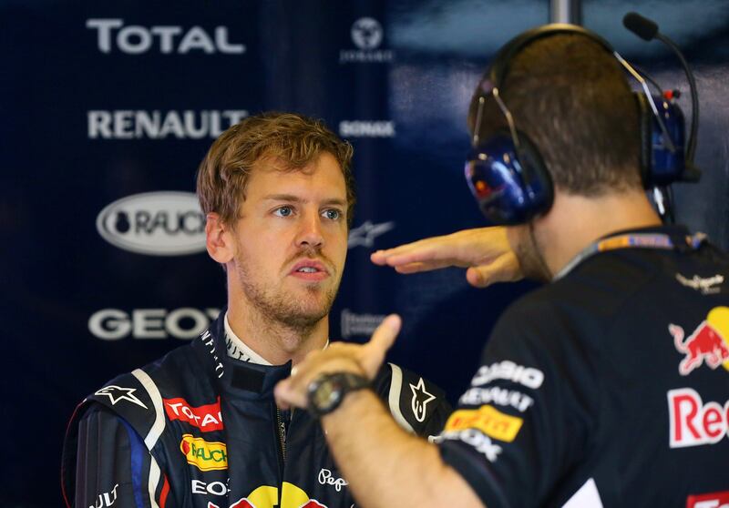 Red Bull Racing's German driver Sebastian Vettel talks to team mates  in the pits during the second practice session at the Yas Marina circuit on November 2, 2012 in Abu Dhabi ahead of the Abu Dhabi Formula One Grand Prix.   AFP PHOTO / MARWAN NAAMANI
 *** Local Caption ***  806393-01-08.jpg