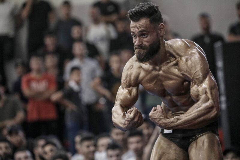 A Palestinian man flexes his muscles as he takes part in a bodybuilding competition in Gaza city. EPA