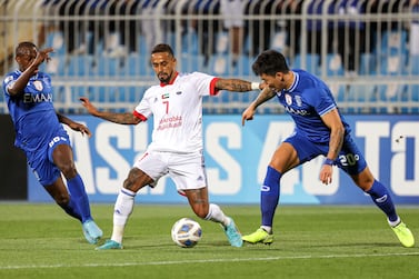 Hilal's defender Saud Abdulhamid (L) and Hilal's defender Jang Hyun-soo (R) vie for the ball against Sharjah's midfielder Caio (C) during the AFC Champions League Group A match between al-Hilal and Sharjah at Prince Faisal bin Fahd Stadium in Riyadh on April 8, 2022.  (Photo by FAYEZ NURELDINE  /  AFP)