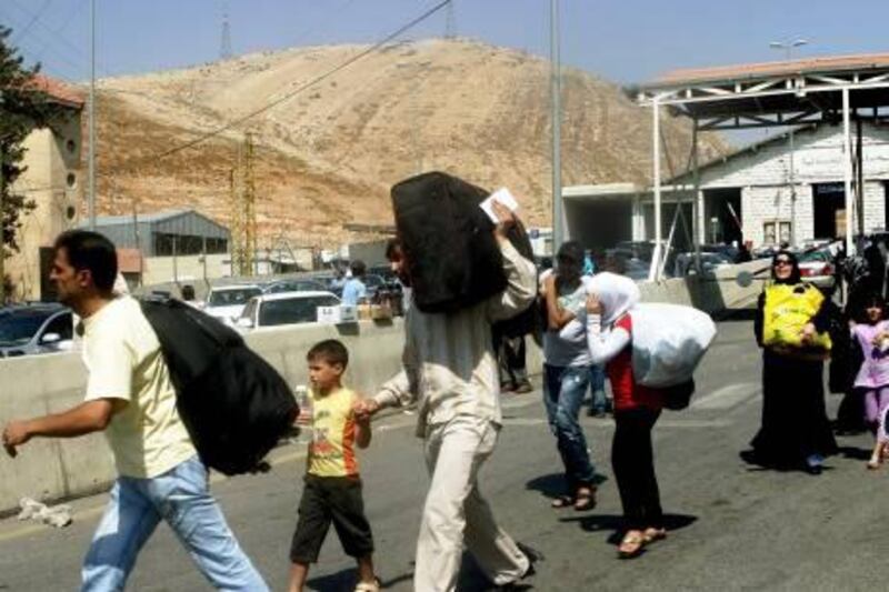 epa03311362 Syrian refugees are seen crossing the Lebanese border post at Al Masnaa area upon their arrival from Syria, in Al Masnaa, Lebanon, 19 July 2012. Unrest in Syria has triggered the departure of thousands of people who fled the violence, some 150,000 went to Jordan while tens of thousands others headed to Turkey and Lebanon.  EPA/LUCIE PARSEGHIAN *** Local Caption ***  03311362.jpg