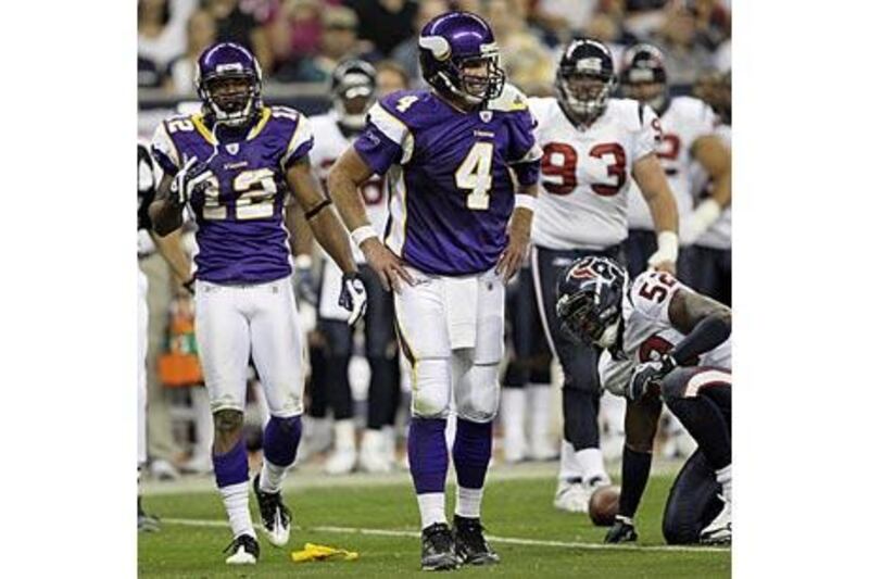 Brett Favre, centre, puts his hands to his hips after being called for an illegal crackback block to the knee of Houston Texans' Eugene Wilson.