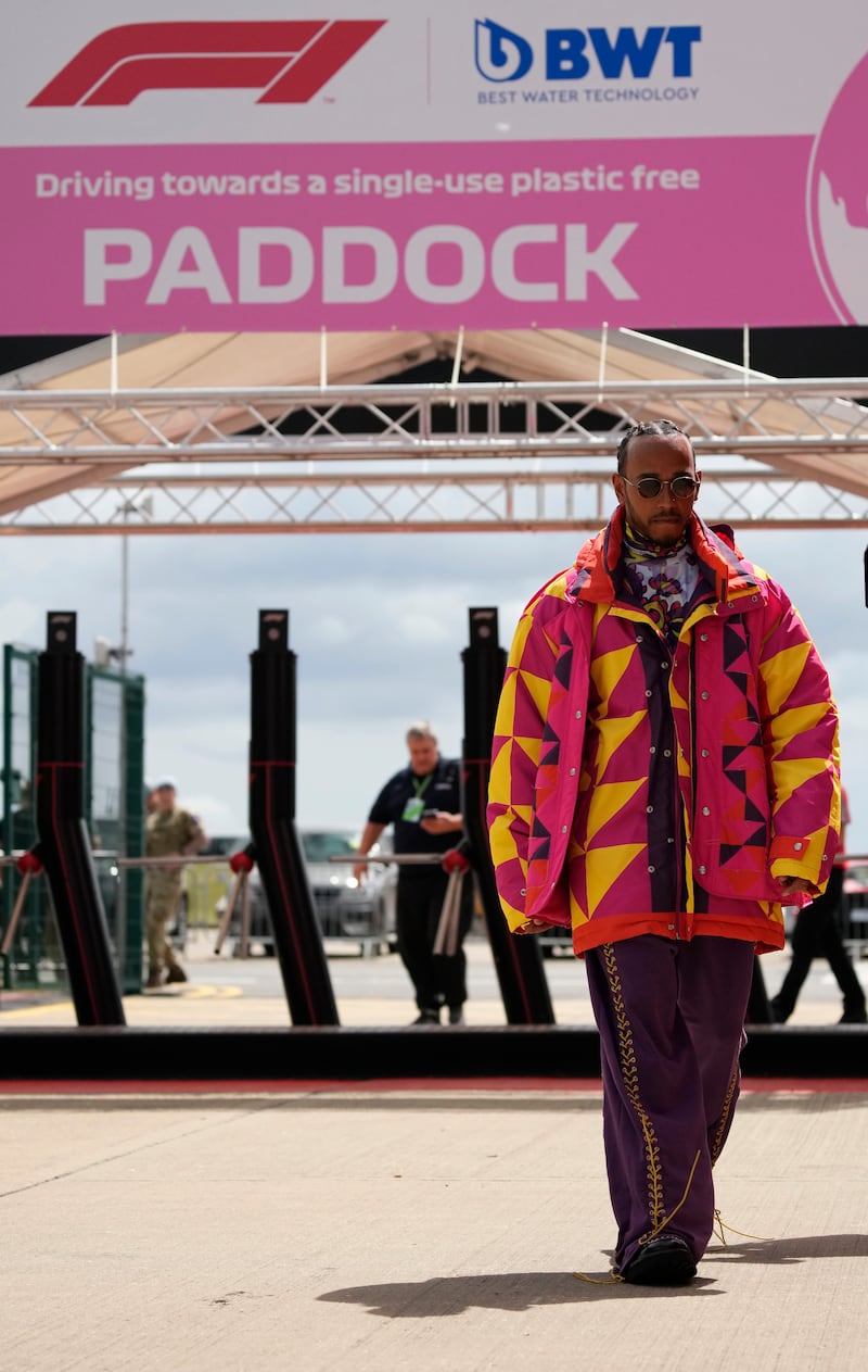 Lewis Hamilton, in a multi-coloured oversized coat by Blue Marble Paris, arrives at the paddock ahead of the British Grand Prix at Silverstone on June 30, 2022. AP