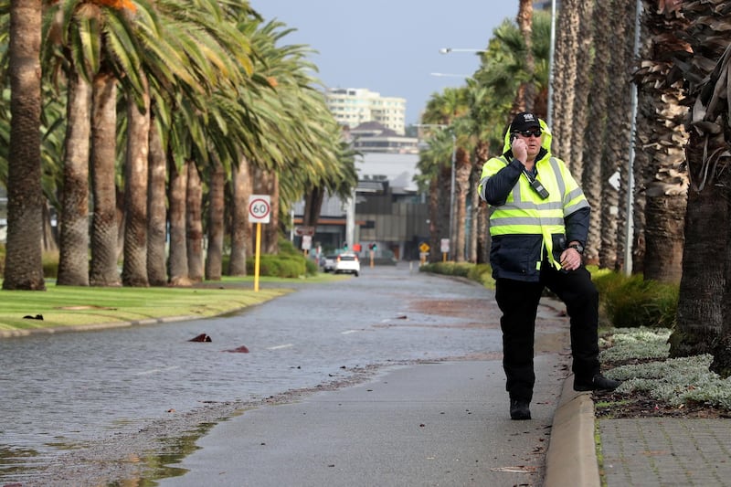 A person is seen on Riverside Drive near the Swan River, which is partially closed due to storm flooding, in Perth, Western Australia.  EPA