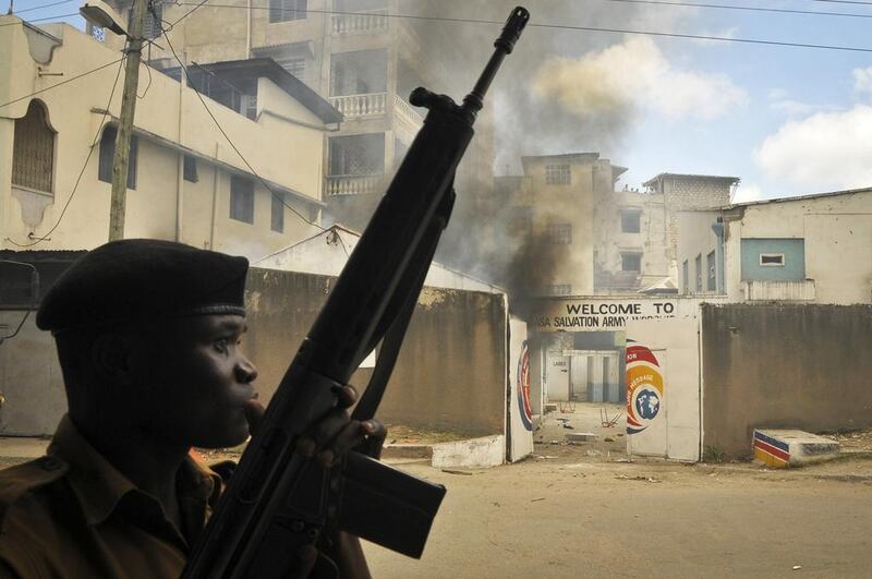 Police guard the Salvation Army Church after it was set on fire during riots in Mombasa on Friday. AP Photo