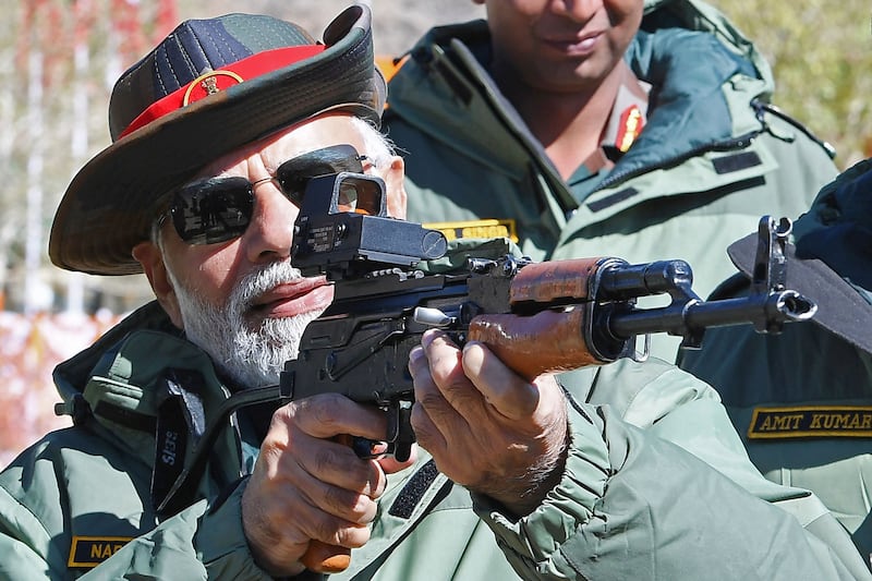 This handout photograph taken on October 24, 2022 and released by the Indian Press Information Bureau (PIB) shows India's Prime Minister Narendra Modi holding a rifle while meeting with the members of Indian armed forces on the occasion of Diwali, the Hindu festival of lights, at Kargil.  (Photo by PIB  /  AFP)  /  RESTRICTED TO EDITORIAL USE - MANDATORY CREDIT "AFP PHOTO / Indian Press Information Bureau (PIB)" - NO MARKETING NO ADVERTISING CAMPAIGNS - DISTRIBUTED AS A SERVICE TO CLIENTS