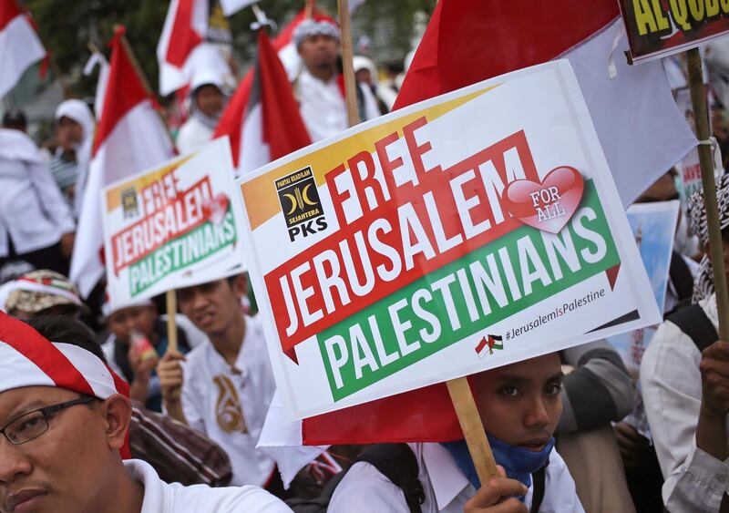 Muslim men hold posters during a rally against President Donald Trump's decision to recognize Jerusalem as Israel's capital outside the U.S. Embassy in Jakarta, Indonesia, Sunday, Dec. 10, 2017. Hundreds of people across the most populous Muslim country staged protests Friday against Trump administration's policy shift on the contested city. (AP Photo/Dita Alangkara)