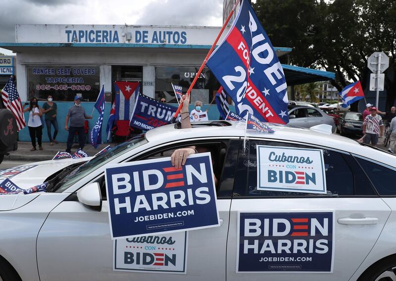 A caravan of supporters for Democratic presidential nominee Joe Biden drive past supporters of President Donald Trump standing on the sidewalk next to the Versailles Restaurant during a Worker Caravan for Biden event  in Miami, Florida. AFP