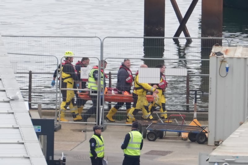 A lifeboat crew carries a person on a stretcher towards an ambulance in Dover, Kent, after a small boat incident in the Channel in which five migrants died in a crossing attempt on April 23. PA