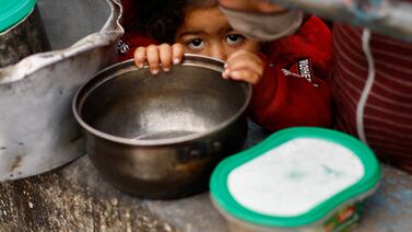 Palestinian children wait to receive food cooked by a charity kitchen amid shortages of food supplies, in Rafah, in the southern Gaza Strip, on February 13. Reuters