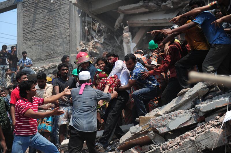 Bangladeshi volunteers evacuate an injured garment worker after an eight-storey building collapsed in Savar, on the outskirts of Dhaka, on April 24, 2013.  At least 82 people have died and 700 are injured after a eight-storey building housing several garment factories collapsed on the outskirts of Bangladesh's capital on Wednesday, a doctor said. AFP PHOTO/Munir uz ZAMAN
 *** Local Caption ***  979065-01-08.jpg