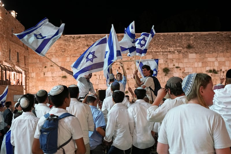 Members of Israeli youth movements dance and wave flags. AP