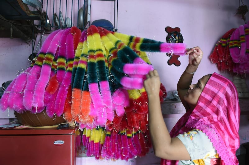 A worker arranges garlands made from coloured polyster/silk yarn ahead of the Hindu festival of Diwali in Ahmedabad on October 17, 2019. Colourful garlands are in demand during the Hindu festival of Diwali, or Festival of Lights, which falls on October 27 this year. Photo: AFP