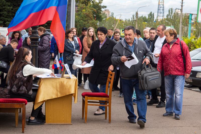 People line up to vote in a referendum in Luhansk in a vote organised by Moscow. AP