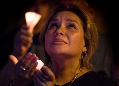 A woman prays during a candlelight vigil at the Immanuel Church for victims of a shooting that left a total of 22 people dead at the Cielo Vista Mall WalMart in El Paso, Texas, on August 5, 2019. US President Donald Trump on Monday told a nation mourning 31 people killed in two mass shootings that he rejected racism and white supremacist ideology, moving to blunt criticism that his divisive rhetoric fuels violence. Trump will visit El Paso, Texas, on Wednesday following a mass shooting in the southern border town that killed 22 people, the local mayor said. / AFP / Mark RALSTON
