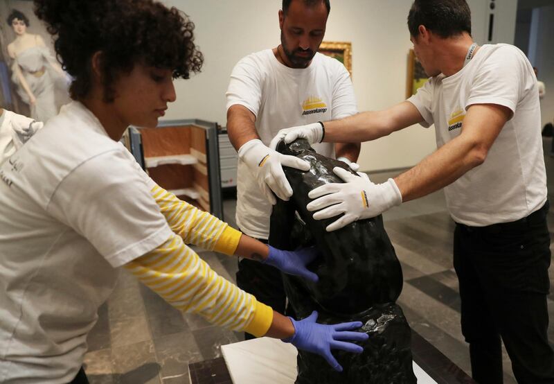 Staff members hold Rodin's 'The Thinker' bronze statue during installation at the Louvre Museum in Abu Dhabi. Kamran Jebreili / AP photo