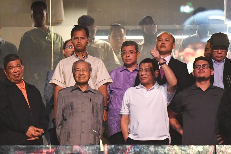 Rodrigo Duterte gestures next to Malaysian Prime Minister Mahathir Mohamad after Philippines' Manny Pacquiao beat Argentina's Lucas Matthysse during their world welterweight boxing championship bout at Axiata Arena in Kuala Lumpur.   AFP