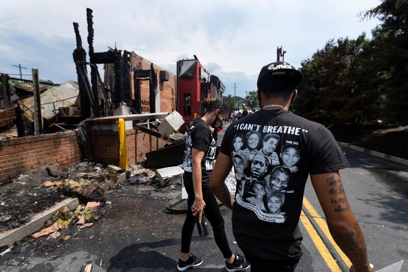 Demonstrators walk around a Wendy's restaurant which was destroyed in Atlanta, Georgia.  EPA