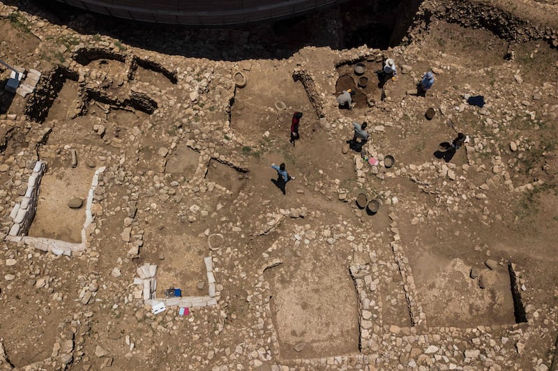 Archaeologists and workers scour the site.