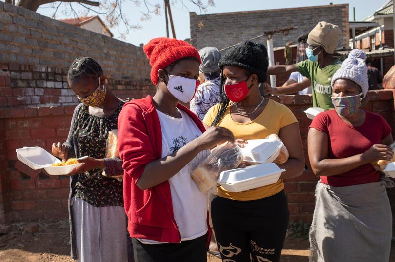 Women receive bread at a food handout during the Eid al Adha at the 'Hunger Has No Religion' feeding scheme, in Johannesburg, South Africa, 01 August 2020. The local Muslim community spent the time they would have shared with family celebrating Eid al-Adha by feeding hundreds who are facing food insecurity due to the effects of the 5th month of pandemic lockdown. EPA