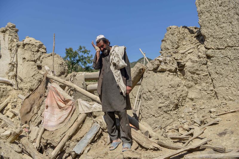 An Afghan man stands besides the ruins of a house damaged after an earthquake in Gayan. AFP