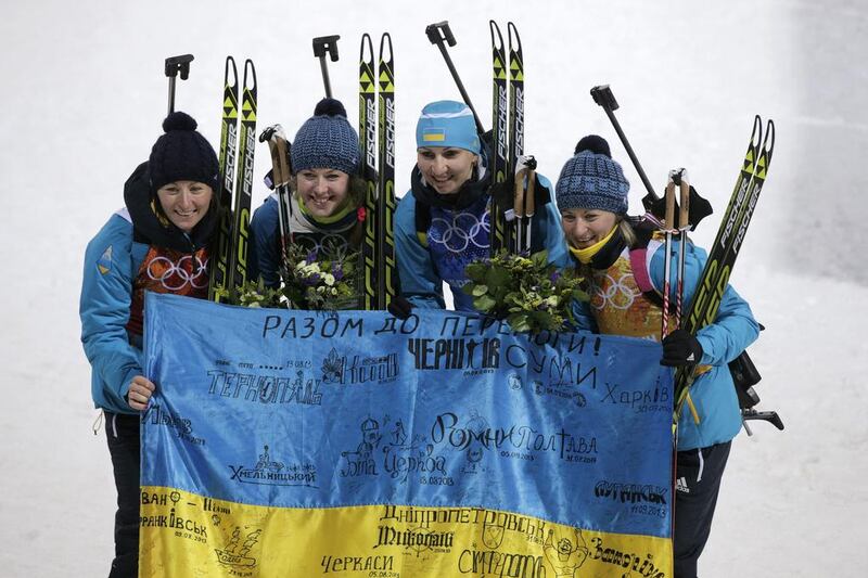 Gold medalists Vita Semerenko, Juliya Dzhyma, Olena Pidhrushna and Valj Semerenko of Ukraine celebrate after the flower ceremony for the women's biathlon 4x6km relay at the Sochi 2014 Winter Olympics on February 21, 2014. Adam Pretty / Getty Images