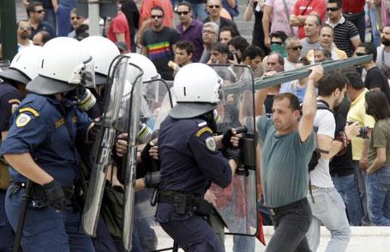 A demonstrator faces off with riot police near the Greek parliament in Athens during a nationwide strike in Greece, on Wednesday, May 5, 2010.