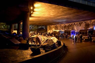 (FILES) In this file photo taken on November 07, 2019 Migrants tents are surrounded by French police and Gendarmerie prior to the evacuation of the makeshift camp in Paris on November 7, 2019. More than a thousand migrants and homeless have settled camp in this area for months. / AFP / MARTIN BUREAU