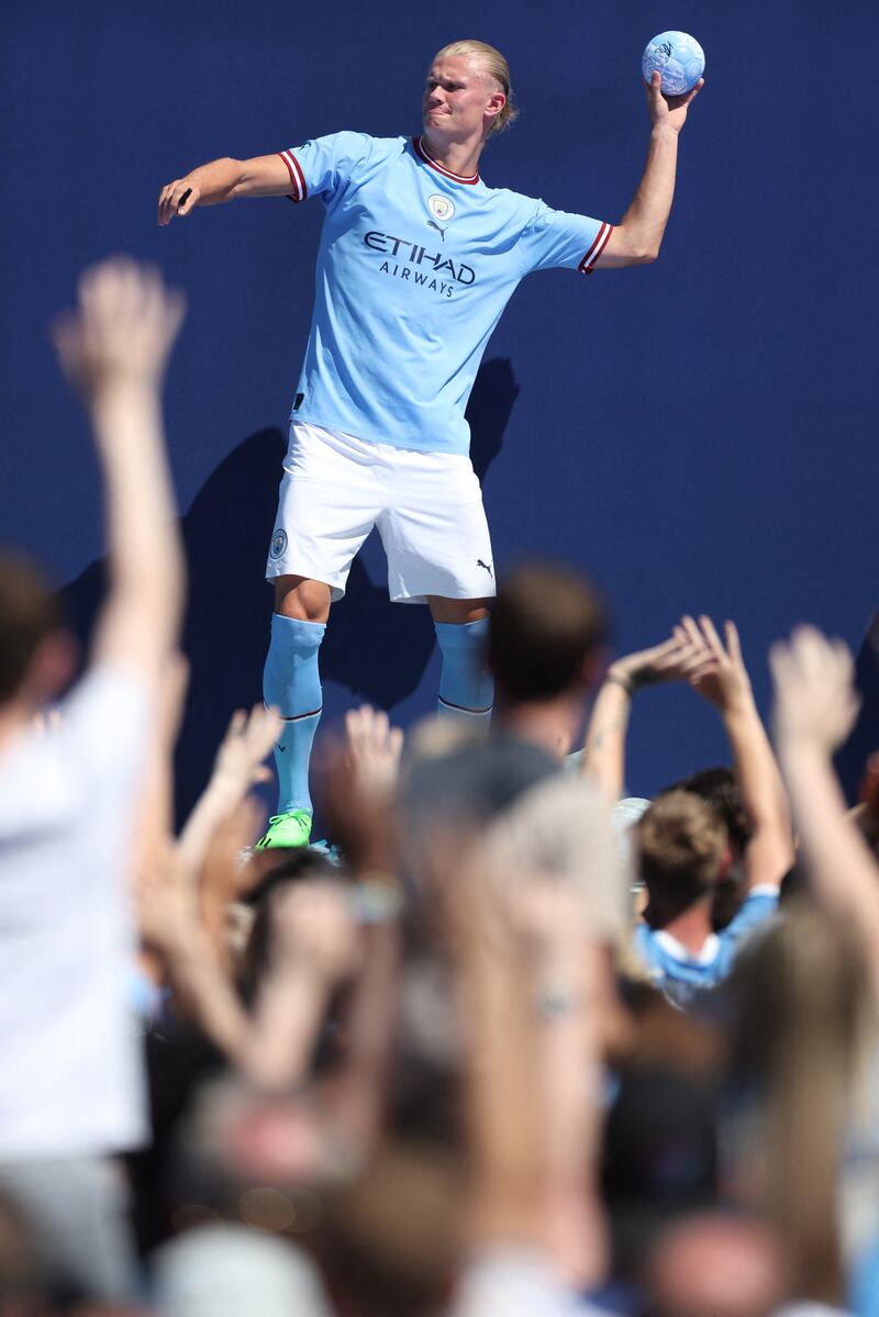Manchester City's Erling Braut Haaland throws a small football signed by him into the crowd. Reuters