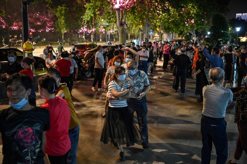 Couples wearing facemasks dance in a park next to the Yangtze River in Wuhan, in China’s central Hubei province.  AFP