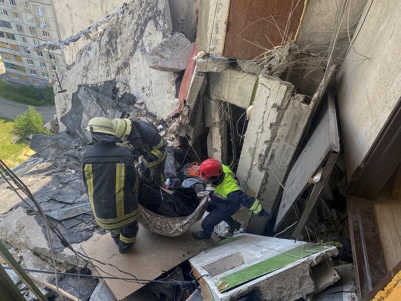 Rescuers carry the body of civilian from a residential building damaged by shelling in Kharkiv, Ukraine. Reuters