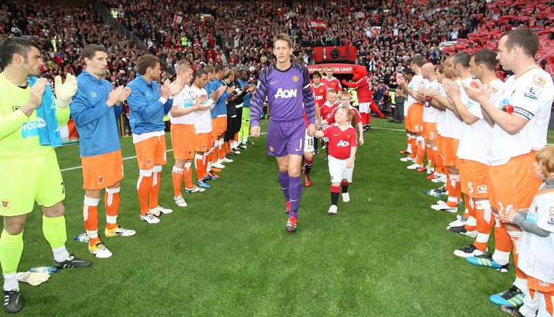 MANCHESTER, ENGLAND - MAY 22:  Edwin van der Sar of Manchester United leads out the Manchester United team through a guard of honour formed by Blackpool ahead of the Barclays Premier League match between Manchester United and Blackpool at Old Trafford on May 22, 2011 in Manchester, England.  (Photo by John Peters/Manchester United via Getty Images)