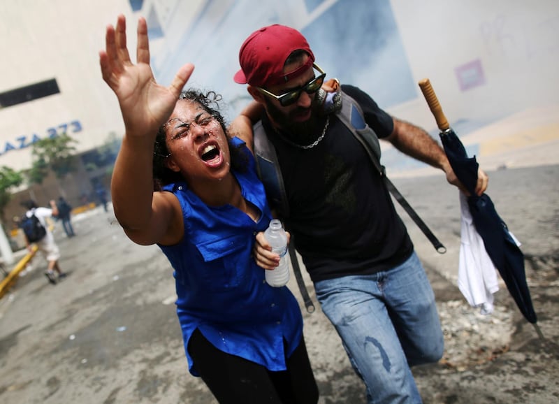 A woman hurt by tear gas is pulled away during a May Day protest in San Juan, Puerto Rico. Alvin Baez / Reuters