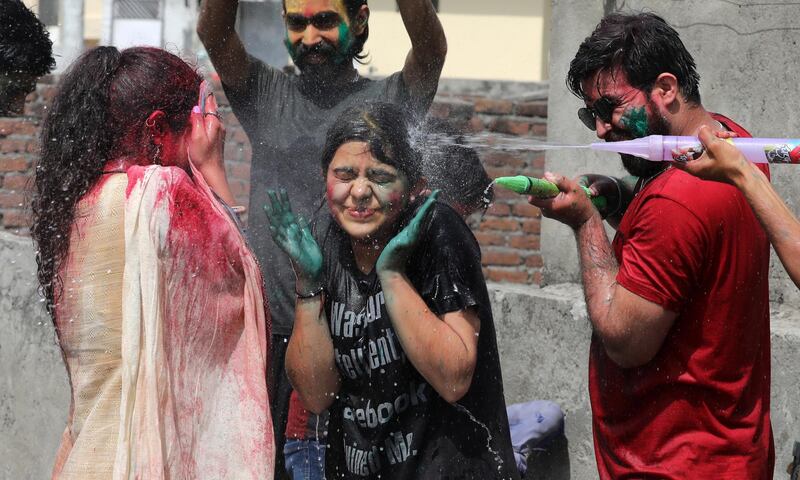Indian people play with water guns as they celebrate the Holi festival in Jammu, the winter capital of Kashmir, India. EPA