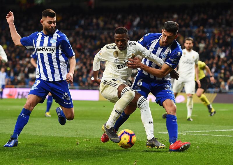 Vinicius  is marshalled by Ruben Duarte and Guillermo Maripan of Alaves. Getty