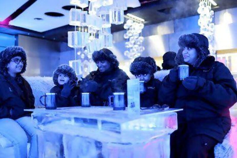 The weekend switch could mean UAE hotels will find it easier to put together packages for Saudi travellers. Above, a Saudi Arabian family drinks hot chocolate at a cafe in Dubai. Ahmed Jadallah / Reuters