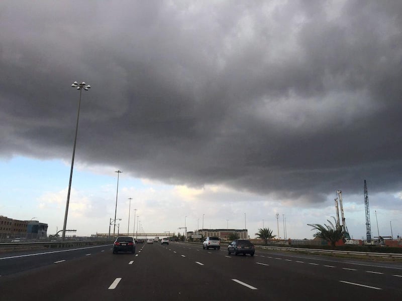 Rain clouds loom over the road to Abu Dhabi at 7am on Sunday morning. Commuters were hit with patches of driving rain from about 8am. Suhail Rather / The National