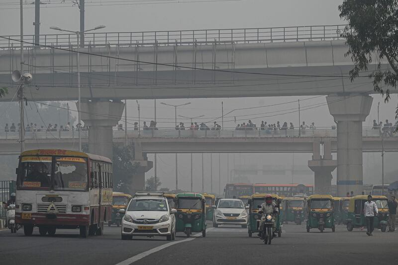 Commuters make their way along a street amid smoggy conditions in New Delhi. AFP