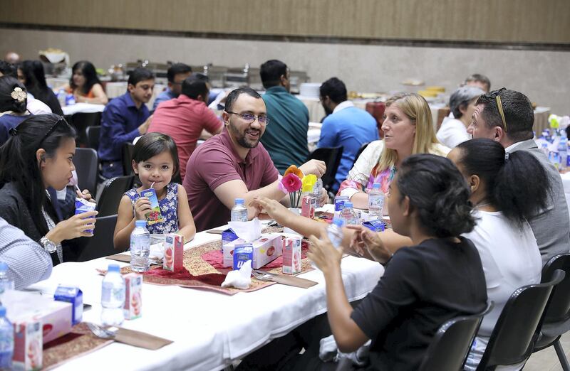 ABU DHABI , UNITED ARAB EMIRATES , JUNE 06 – 2018 :- People having their food during the iftar held at St Andrew’s Church in Abu Dhabi.  ( Pawan Singh / The National )  For News. Story by John