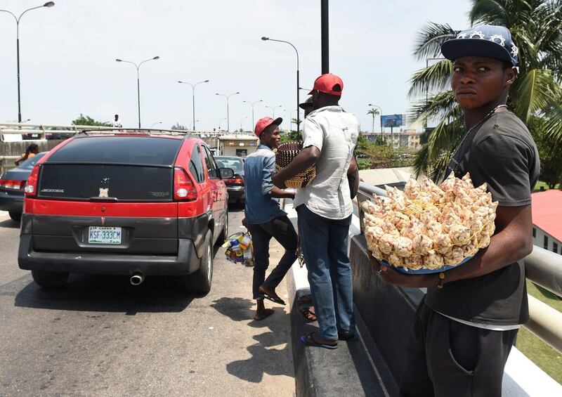 A file photo showing a street vendor who is selling his wares on a road of Lagos. Nigerian authorities are now clamping down on hawkers such as these, threatening those who continue doing so with up to six months in jail and a fine of 90,000 naira if they're caught. Pius Utomi Ekpei/AFP