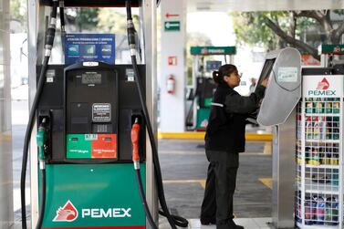 An employee makes a payment next to fuel pumps at a Pemex gas station in Mexico City. The company is drowning in debt, its oil output is declining, and now it appears to be losing fuel market share in its own backyard. Reuters