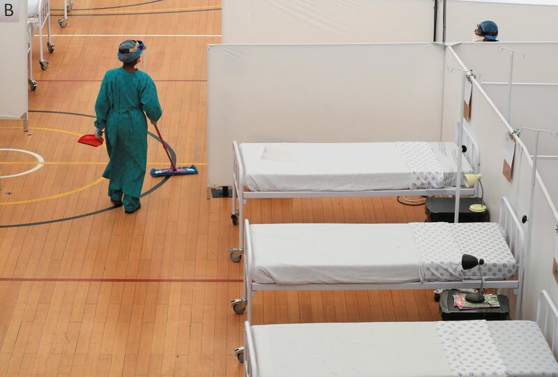 A health worker walks between beds at a temporary field hospital set up in a sports complex by Medecins Sans Frontieres during the Covid-19 outbreak in Khayelitsha township near Cape Town, South Africa. Reuters