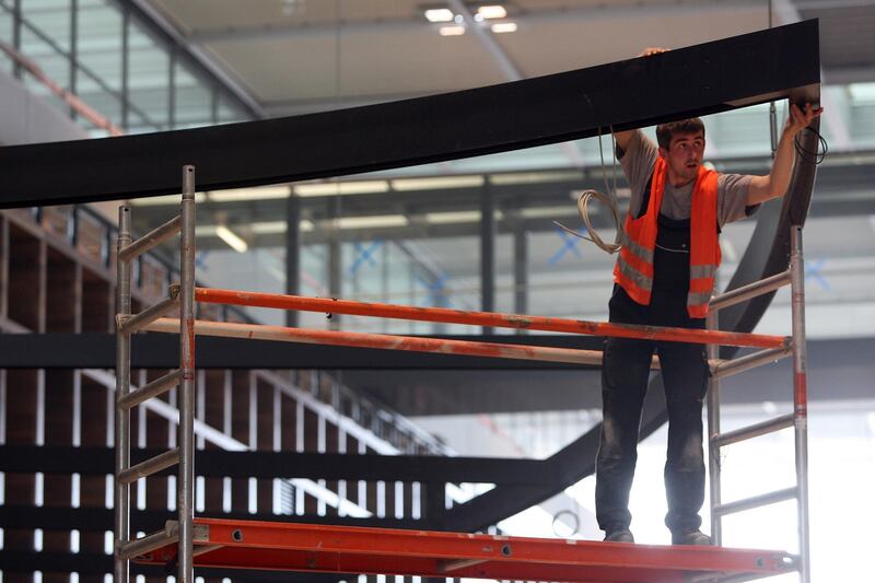 BERLIN, GERMANY - MAY 04:  A worker installs an awning in the departures area at Berlin Brandenburg Airport (IATA code BER) on May 4, 2012 in Schoenefeld, near Berlin, Germany. The new airport, located south of Berlin, is scheduled to open on June 3 and will replace three airports: Tempelhof Airport expanded by the Nazis which closed in 2008, Tegel Airport, scheduled to close later this year, and Schoenefeld Airport, which currently exists at the site of the new facility and was opened in 1934 to host an aircraft plant. The new airport, designed for a capacity of 27 million passengers a year, has cost nearly three billion euros to construct, controversial in a city that has one of the highest levels of unemployment in the country, at twice the German national average. Proponents of the new airport contend that the building may salvage the capital city which has struggled economically in recent years.  (Photo by Adam Berry/Getty Images)