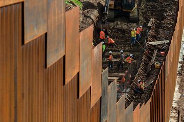 Workers reinforce a section of the US-Mexico border fence, as seen from eastern Tijuana, in Baja California state, Mexico. AFP 